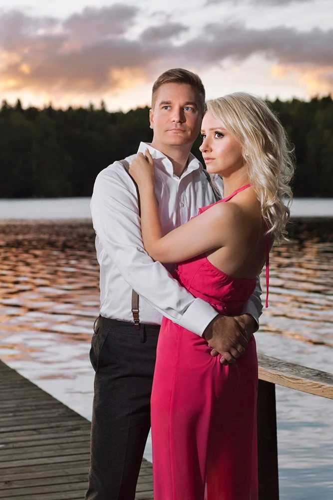 Juhlapukuinen pari järven rannalla